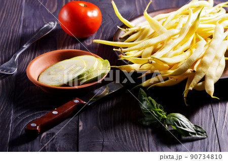 Green and yellow bean pods of asparagus on old rustic wooden table. Green and yellow bean pods of asparagus on old rustic wooden table. 90734810