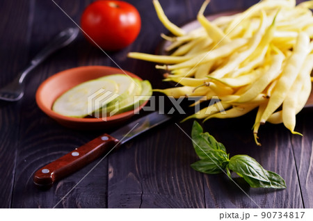 Green and yellow bean pods of asparagus on old rustic wooden table. Green and yellow bean pods of asparagus on old rustic wooden table. 90734817