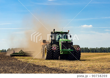 The tractor plows the land. Agriculture image. 90738269