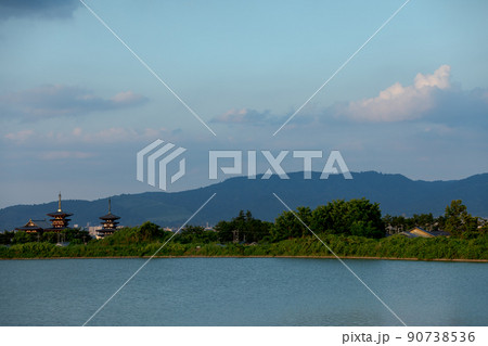 若草山と夏空を背景に夕日に照らされる薬師寺伽藍 90738536