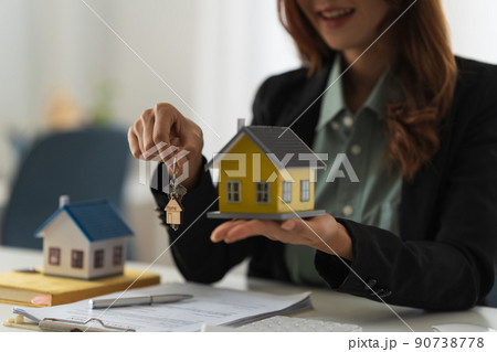 Real estate or broker residential or Agent showing key for house to customer after sign in agreement contract. 90738778