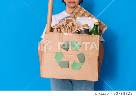 Girl holding a box with garbage for recycling Girl holding a box with garbage for recycling 90738825