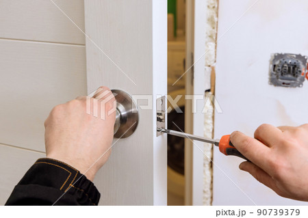 Locksmith install the door lock in house. 90739379