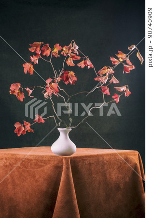 Autumn still life with a viburnum branch in a white vase 90740909