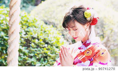 桜吹雪とお参りする女性 90741270