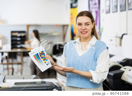 Portrait of positive woman printing office worker with colour test page 90741599