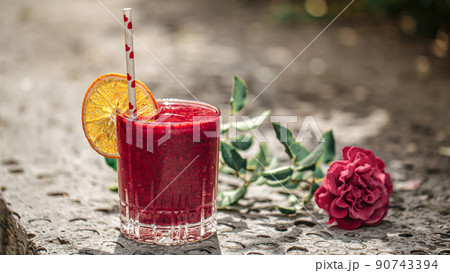 Glass of fresh berry smoothie with orange slice Glass of fresh berry smoothie with orange slice 90743394