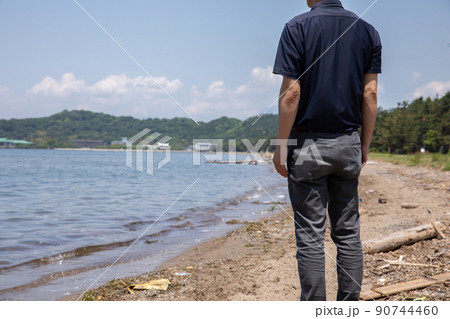 波打ち際で遠くを見つめる男性　beach 90744460