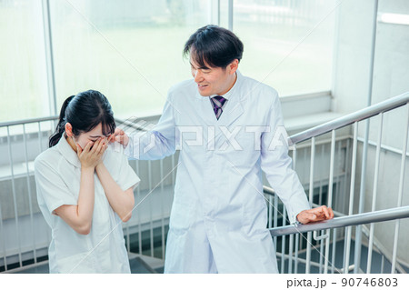 泣く看護師を励ます男性医師 90746803