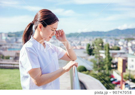 屋上で思い悩み泣く看護師の女性 屋上で思い悩み泣く看護師の女性 90747058