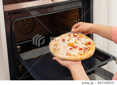 Italian pizza with cheese and tomatoes cooking dinner in a modern kitchen 90749859