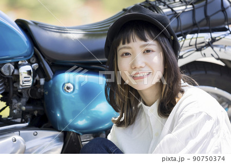 バイク女子イメージ　バイクの横に座る若い女性 90750374