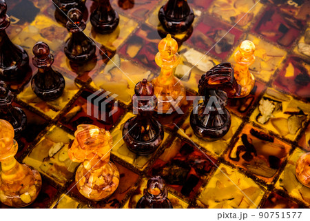 Natural amber different chess pieces figures standing on brown stone board. Close up game concept competition, Classic Gambit Tournament of confrontation. Natural amber different chess pieces figures standing on brown stone board. Close up game concept competition, Classic Gambit Tournament of confrontation. 90751577