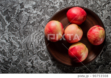 Background of bright and ripe nectarines in full screen. Autumn wallpaper of exotic southern fruits. The concept of harvesting. 90753508
