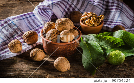 Walnut kernels on a dark table with a colored background Walnut kernels on a dark table with a colored background 90754224