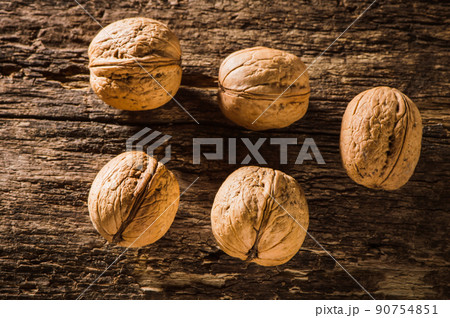Walnut kernels and whole walnuts on an old wooden Walnut kernels and whole walnuts on an old wooden 90754851