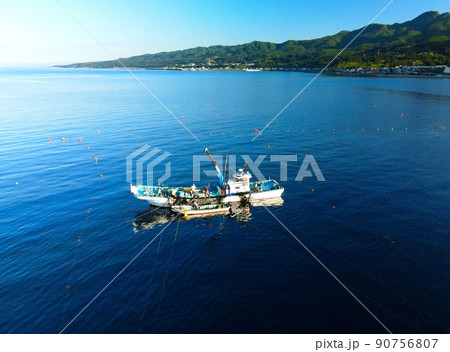 初夏の北海道八雲町熊石で定置網漁をする漁船の風景を空撮 初夏の北海道八雲町熊石で定置網漁をする漁船の風景を空撮 90756807
