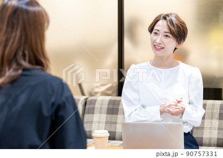 オフィスの休憩スペースで相談を受けるミドル女性 90757331
