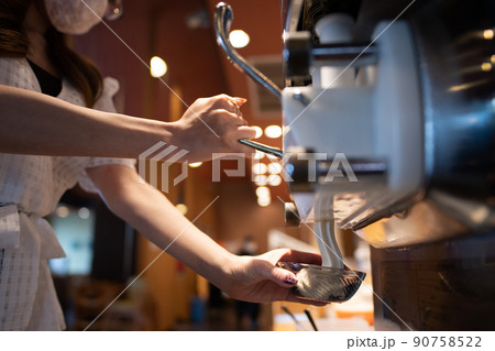 ソフトクリームを器に盛る女性の手 90758522