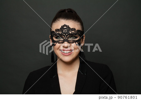 Portrait of attractive woman with carnival black mask smiling cheerfully 90761801