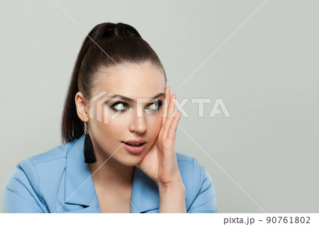 Pretty model woman brunette looking aside at copy space on gray background Pretty model woman brunette looking aside at copy space on gray background 90761802