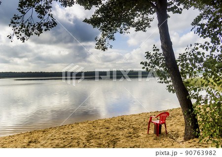 red chear on lake beach red chear on lake beach 90763982