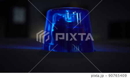 Blue flashing warning light in the dark close up. 90765409