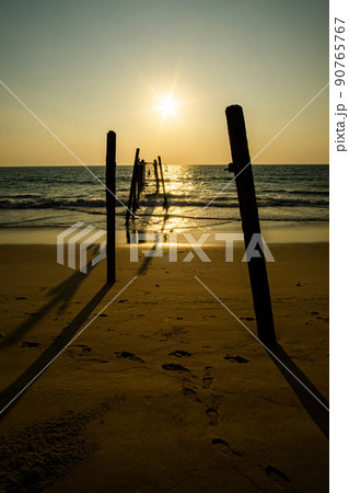 Sunset and reflections from the sea, decaying wooden bridges, Khao Pi Lai Phang Nga beach, Thailand 90765767