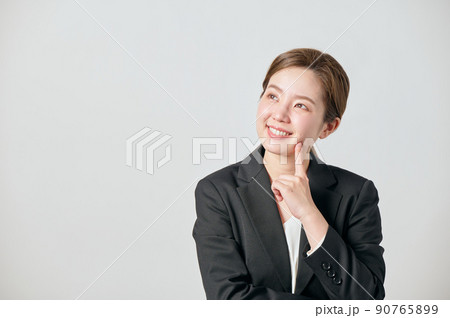 考え事をするジャケット姿の若い女性 90765899