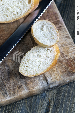wheat baguette cut into pieces on a cutting board 90767171