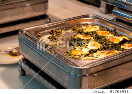 All-inclusive buffet food in heating trays in hotel restaurant with eggs with spinach for breakfast All-inclusive buffet food in heating trays in hotel restaurant with eggs with spinach for breakfast 90768958