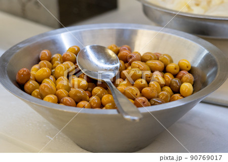 Closeup of marinated green olives in bowl on table Closeup of marinated green olives in bowl on table 90769017