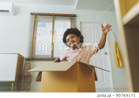 Happy African American Boy curly hair playing with cardboard box 90769175