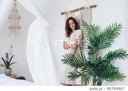 Portrait of a young woman standing in the bedroom 90769867
