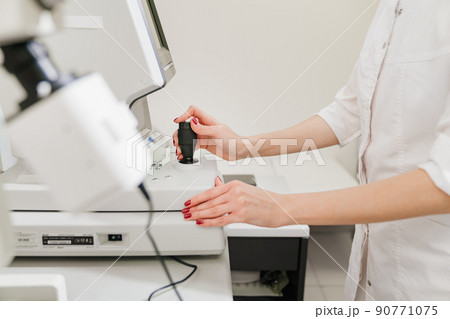doctor examines eyes on screen of autorefractometer. doctor examines eyes on screen of autorefractometer. 90771075