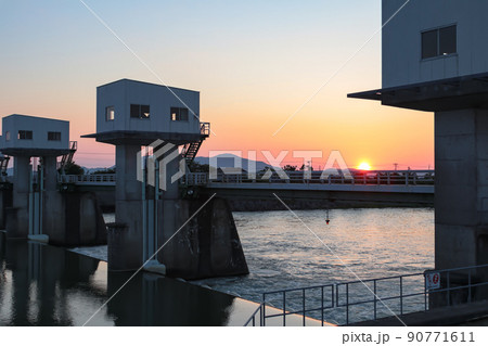 大島頭首工 (三条市、新潟市南区 中ノ口川) と沈む夕日 大島頭首工 (三条市、新潟市南区 中ノ口川) と沈む夕日 90771611