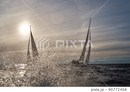 Sailing yachts in regatta at sunset, sailing regatta, hot pursuit, splashes of water, the clear sky  90772408