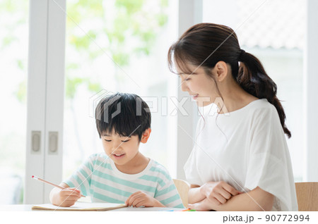 リビングで勉強する男の子と母親 90772994