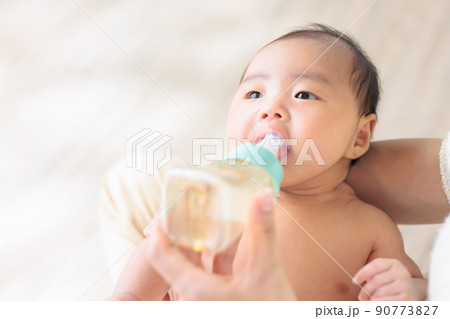 哺乳瓶をくわえる赤ちゃん　生後1ヶ月　コピースペース 90773827