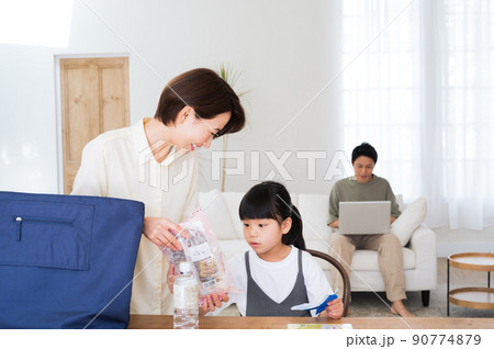 エコバックから買い物を取り出す母親と家族 エコバックから買い物を取り出す母親と家族 90774879
