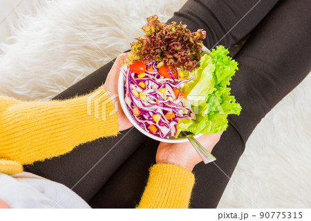 Female hands holding bowl with green lettuce salad 90775315