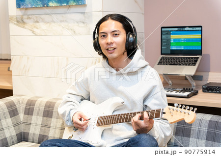 白いエレキギターを弾く若い男性 白いエレキギターを弾く若い男性 90775914