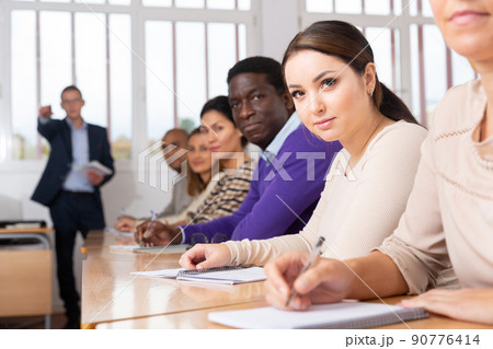 Side view of student group working on lecture in classroom,  90776414