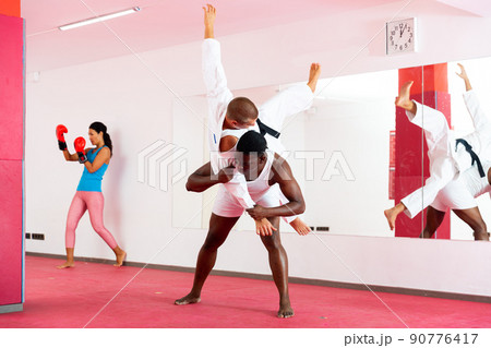 People training martial arts moves in gym 90776417