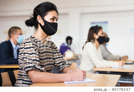 Group of adult students in protective masks at lecture at university Group of adult students in protective masks at lecture at university 90776537