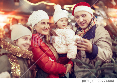Man and his family buying Christmas tree Man and his family buying Christmas tree 90776808