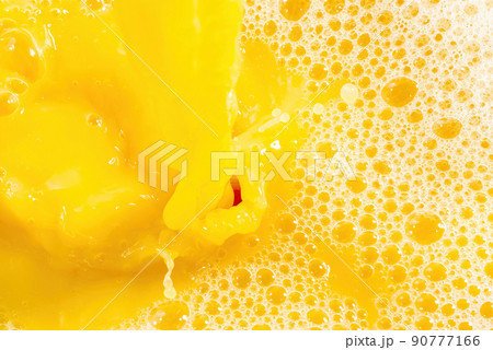 Closeup of splashing orange juice, top view. Splash of fresh sweet orange, mango, fruit juice. Closeup of splashing orange juice, top view. Splash of fresh sweet orange, mango, fruit juice. 90777166