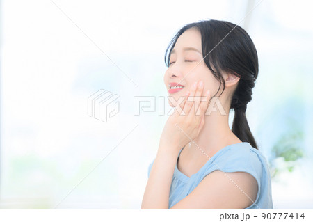 お肌を気にする女性 目を閉じる お肌を気にする女性 目を閉じる 90777414