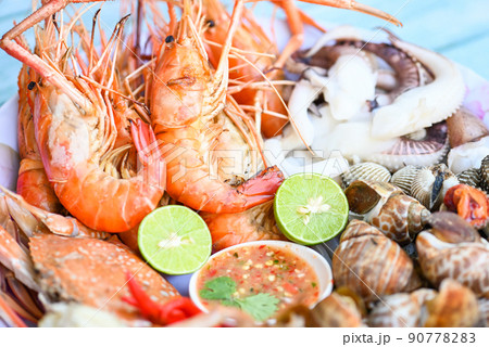 seafood plate with shrimp shellfish crab squid cockle spotted babylon with seafood sauce chili lemon lime serve on dining table, shrimps prawns seafood buffet menu cooked food seafood plate with shrimp shellfish crab squid cockle spotted babylon with seafood sauce chili lemon lime serve on dining table, shrimps prawns seafood buffet menu cooked food 90778283