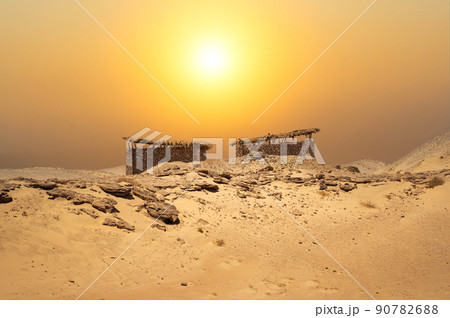 Small huts in the middle of the desert with an amazing landscape background. Desert stone hut. dust storm. 90782688